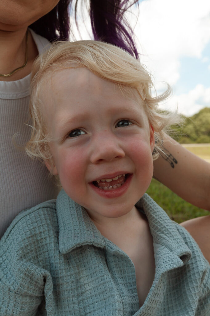 Toddler look at camera with a smile on his face during family session in Atlanta, GA.